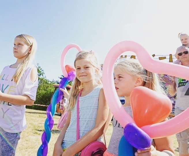 Kinderen op een zomers evenement met kleurrijke ballonkunstwerken